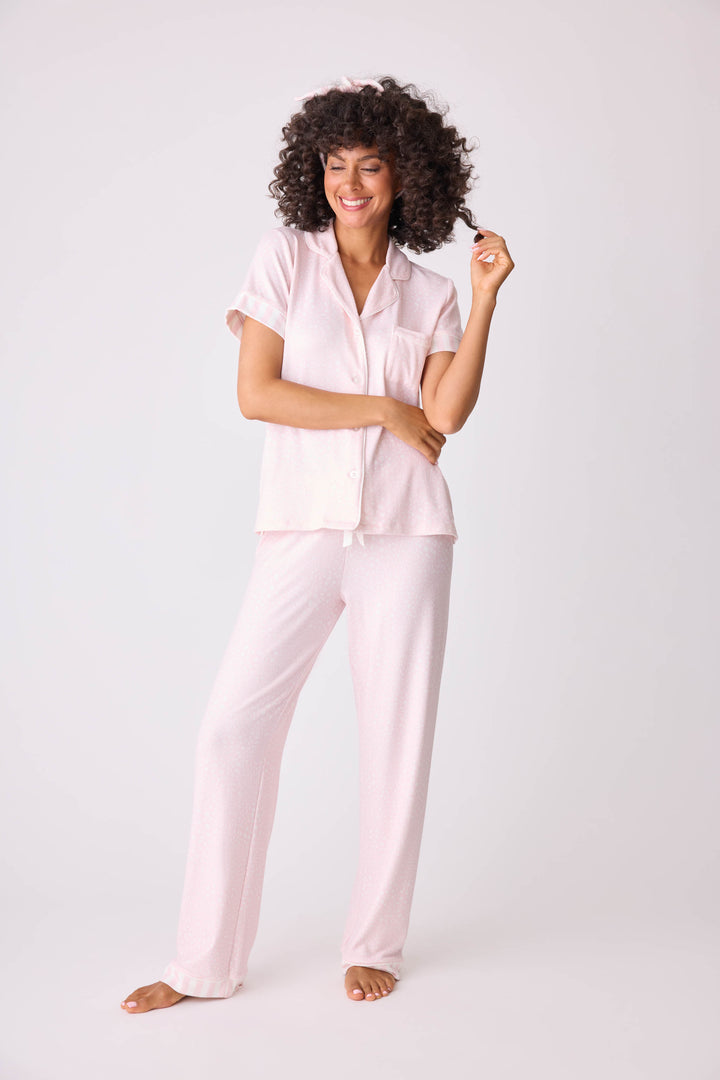 Women's 3-piece pajama set in light pink-ivory leopard dot. Short sleeve button-front top & open leg pant with contrast pink striped cuffs. Includes matching hair wrap. Exclusive collab with Susan G. Komen style.