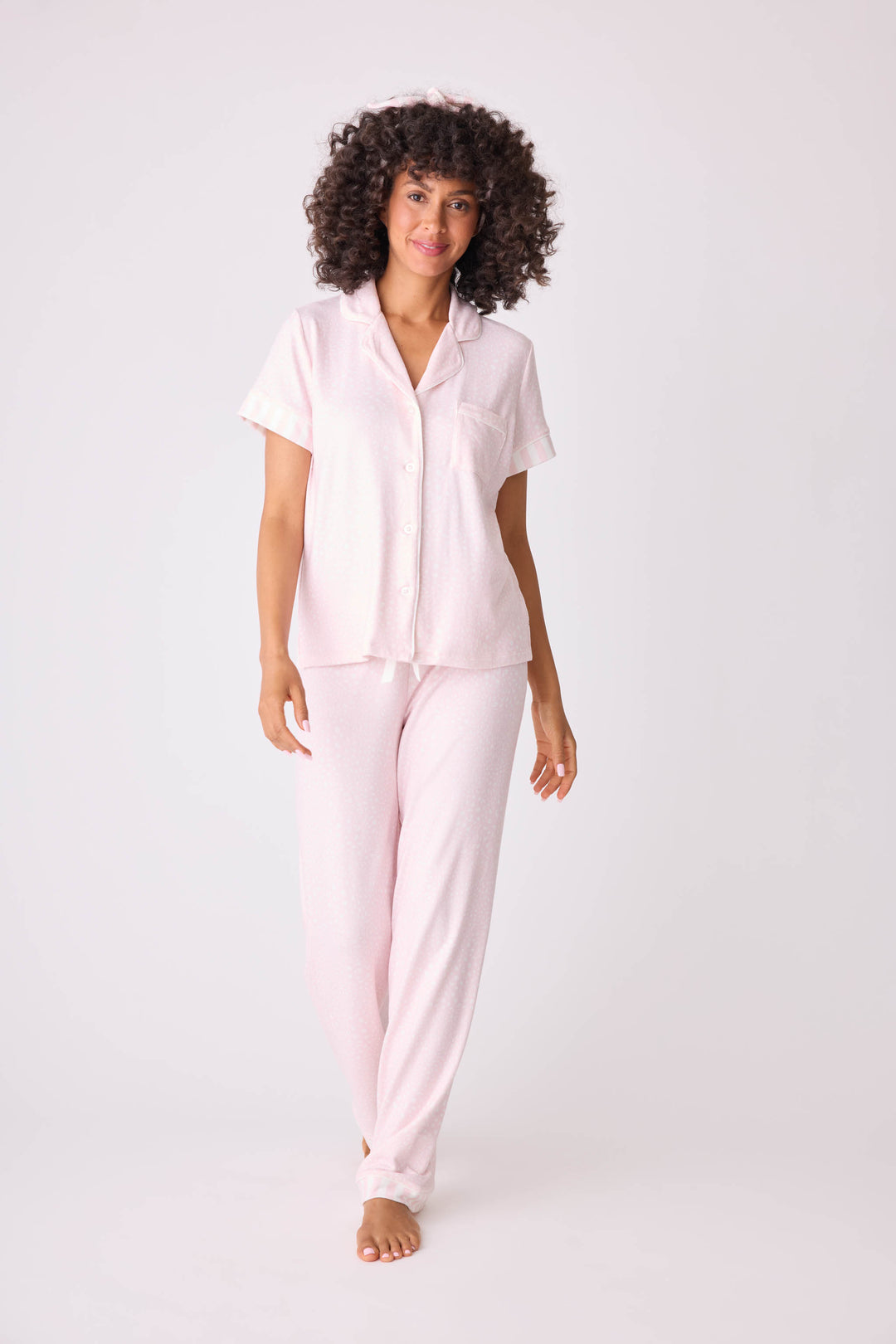 Women's 3-piece pajama set in light pink-ivory leopard dot. Short sleeve button-front top & open leg pant with contrast pink striped cuffs. Includes matching hair wrap. Exclusive collab with Susan G. Komen style.