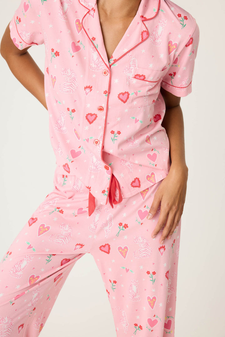 Women's breathable cotton-modal jersey short sleeve pajama set in pink mini tiger & heart print with contrast red piping. Button-front top & open leg tie-waist pant.