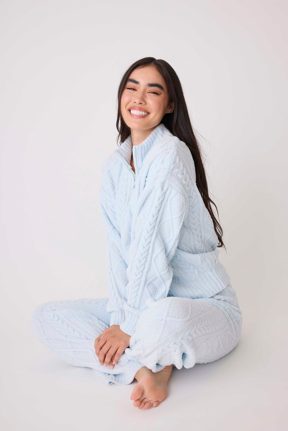 Women's cable texture quarter-zip pullover in light blue knit. With high-neck collar & rib knit waistband.