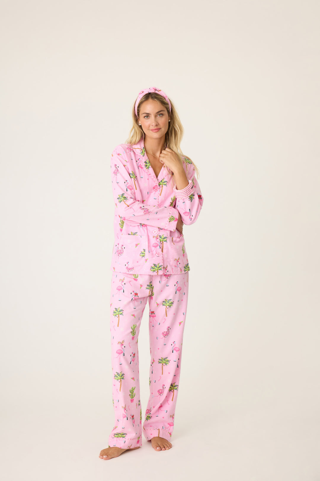 Women's cotton flannel pajama set in pink with retro flamingo print. Button-front collared top & tie-waist pant. Embroidered sleeve cuff "Let's Jingle & Flamingle". Includes matching hair wrap.