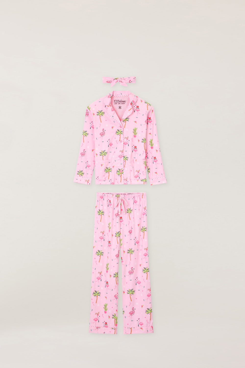 Women's cotton flannel pajama set in pink with retro flamingo print. Button-front collared top & tie-waist pant. Embroidered sleeve cuff "Let's Jingle & Flamingle". Includes matching hair wrap.