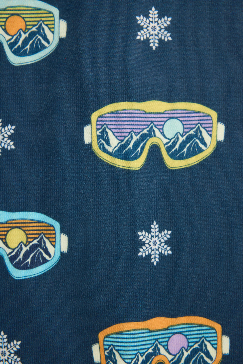 Baby's onesie pajama set in gender-neutral navy with snow-goggle print.