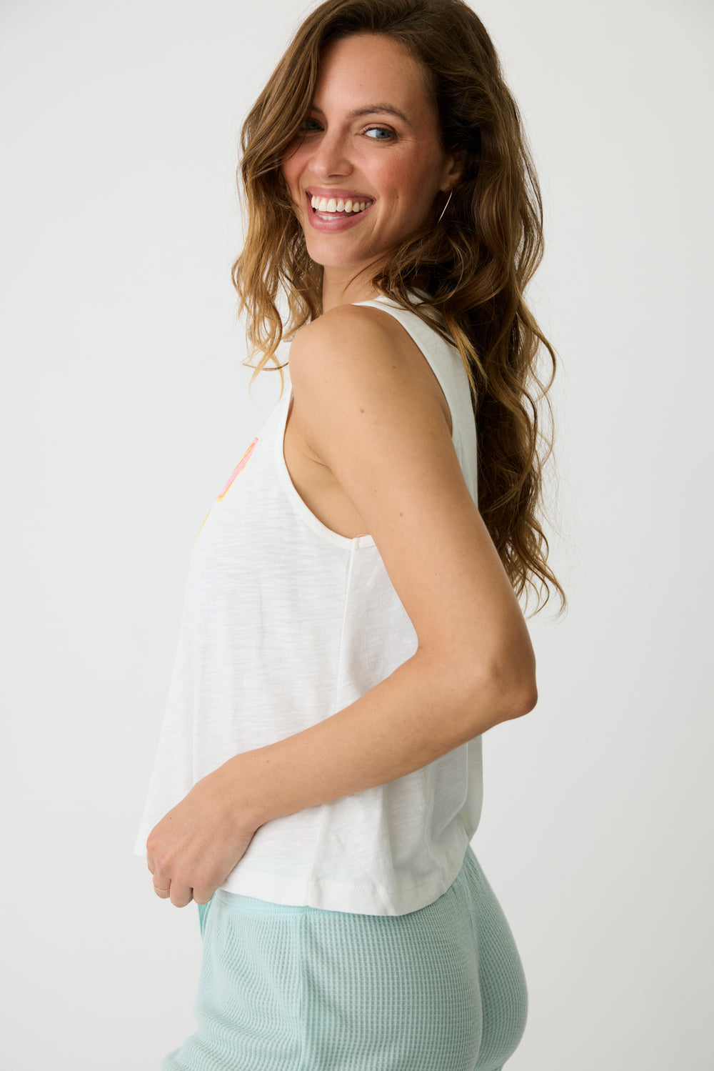 Women's ivory graphic print tank top with open hem. 'Take it easy' print on chest.