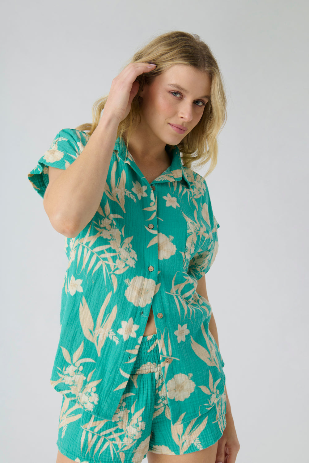 Women's short sleeve cotton woven gauze with green tropical print. Button-front with chest pocket.