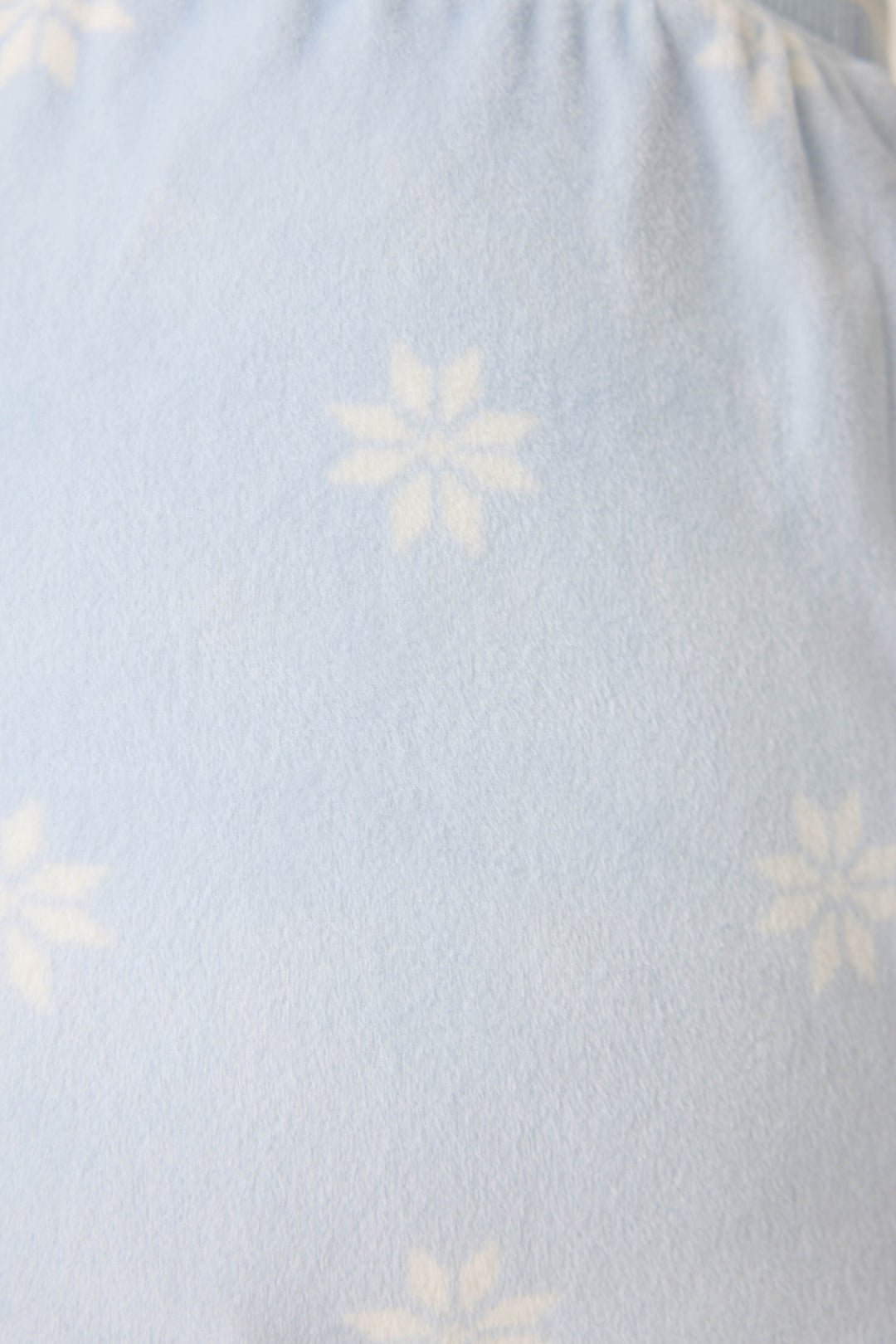 Women's long sleeve pale blue PJ top with white snowflake pattern.