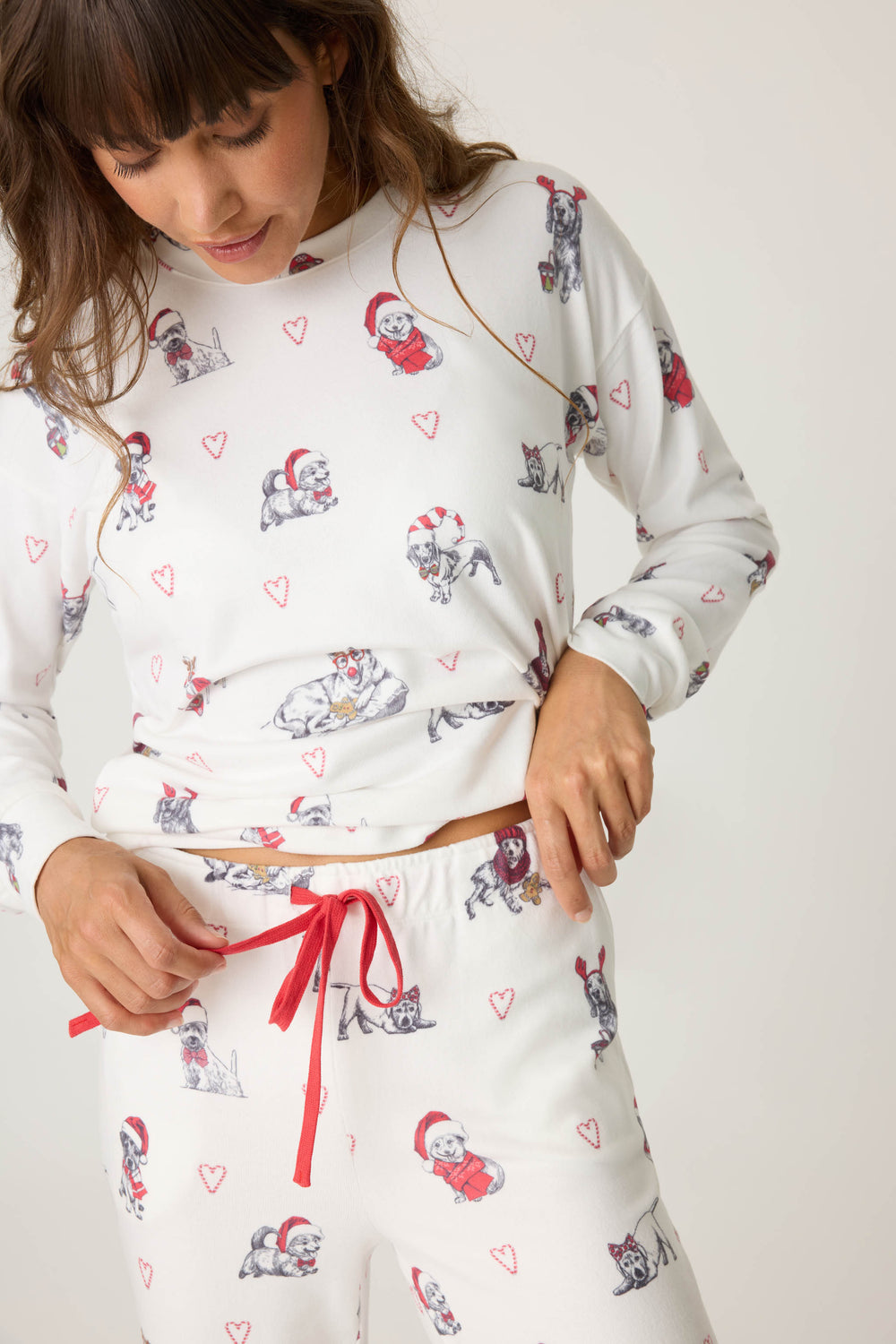 Women's white jammie top and banded PJ pant with holiday dog with red hats pattern.