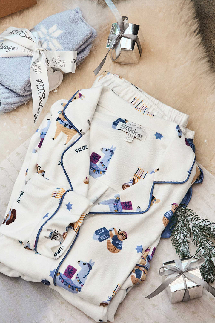 Women's white collared PJ top and tie waist pant with Hanukkah llama pattern.