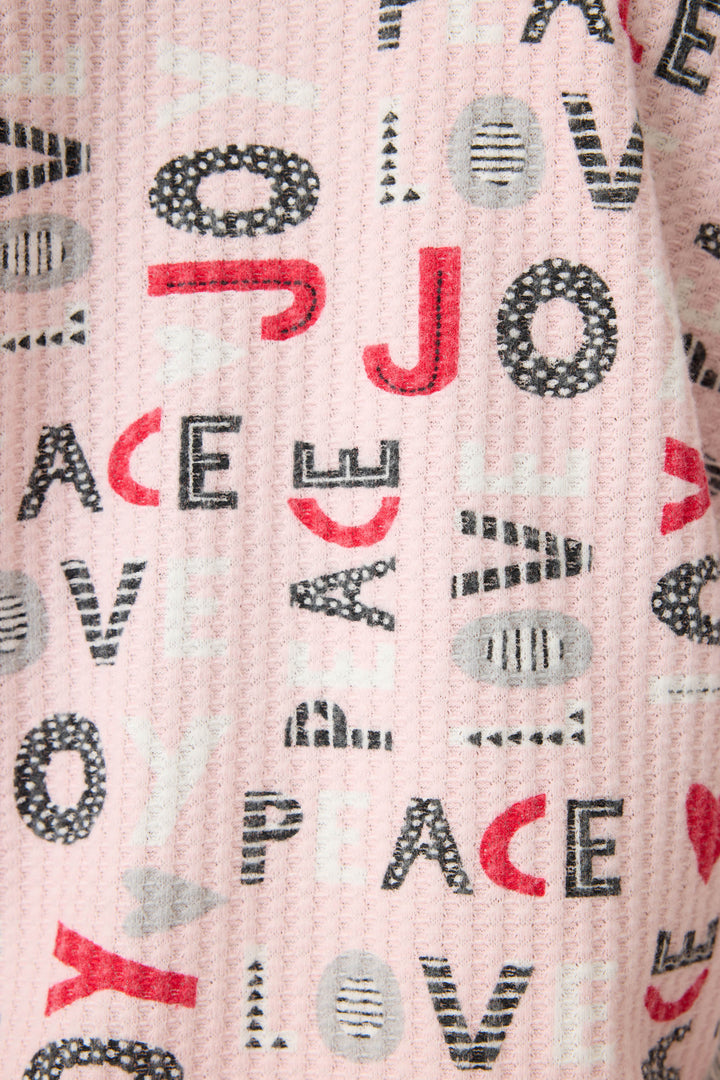 Women's pale pink jammie top and banded PJ pant with joy and peace pattern.