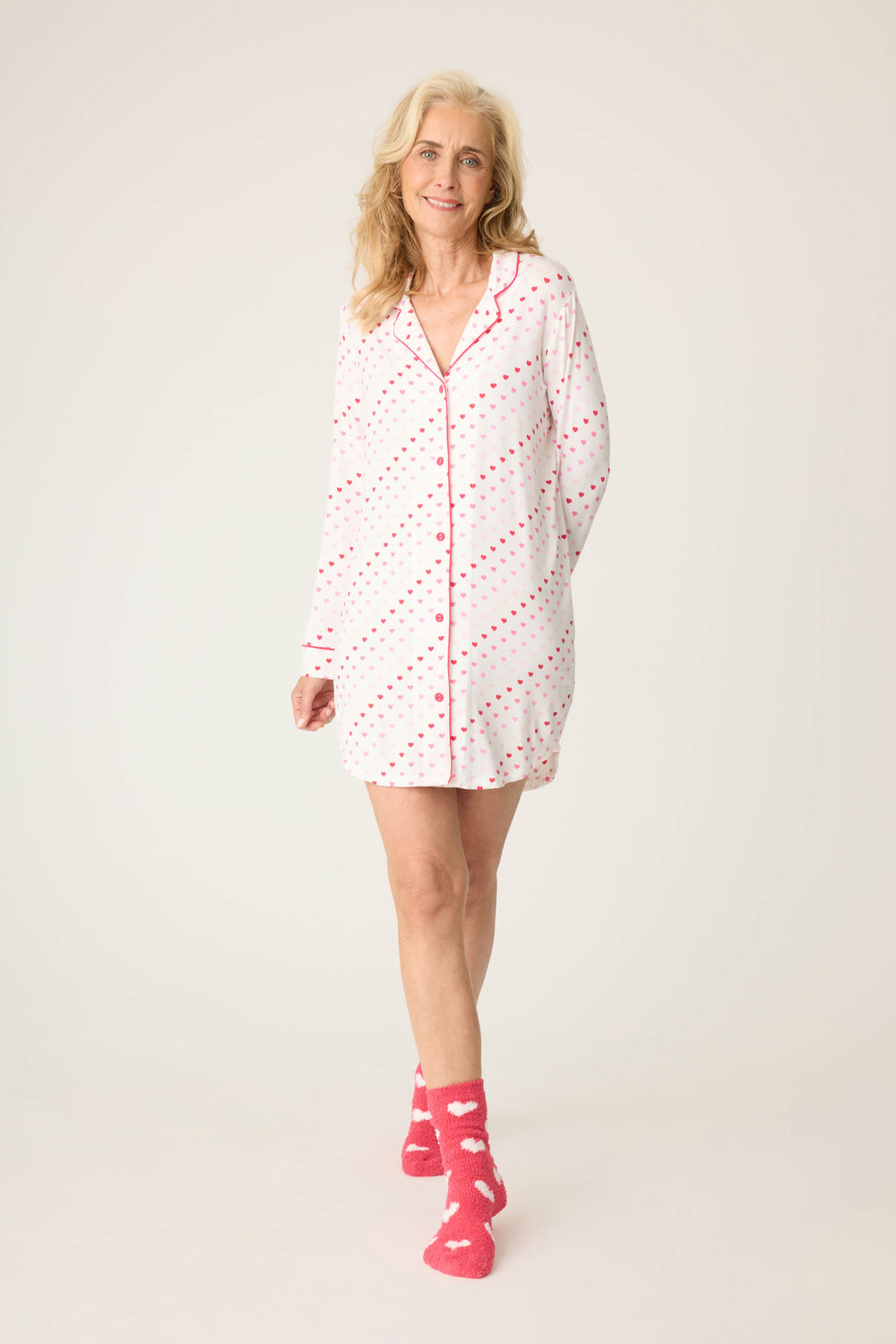 Women's white collared long sleeve night shirt with pink heart pattern.