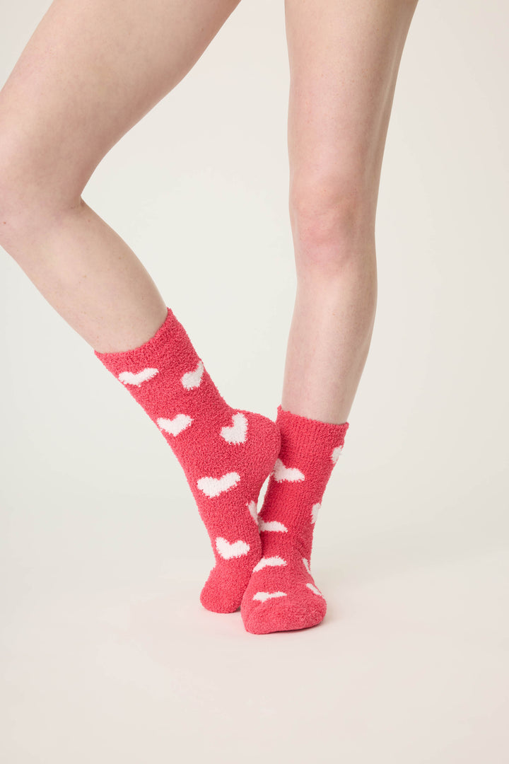 Women's red socks with white heart pattern.