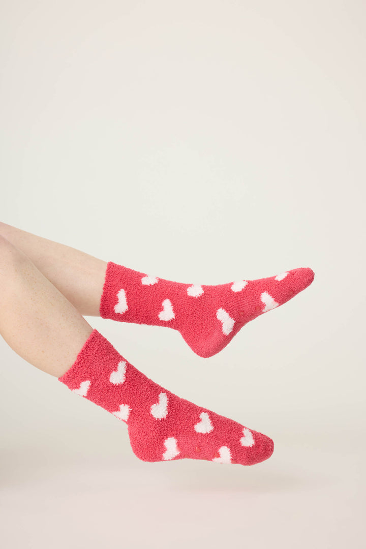 Women's red socks with white heart pattern.