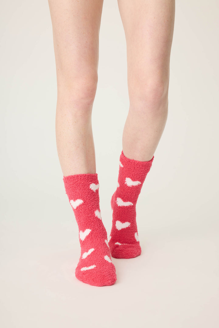 Women's red socks with white heart pattern.