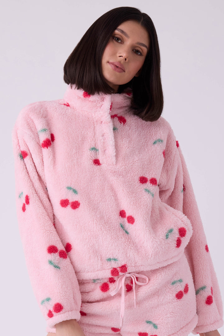 Women's pink fuzzy faux fur jacket with cherry pattern.