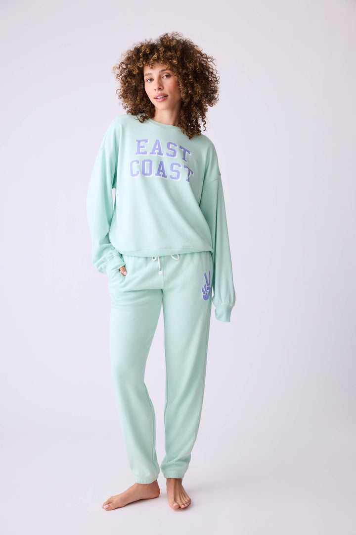 Women's vintage fleece jogger set in light green with EAST COAST graphic print.