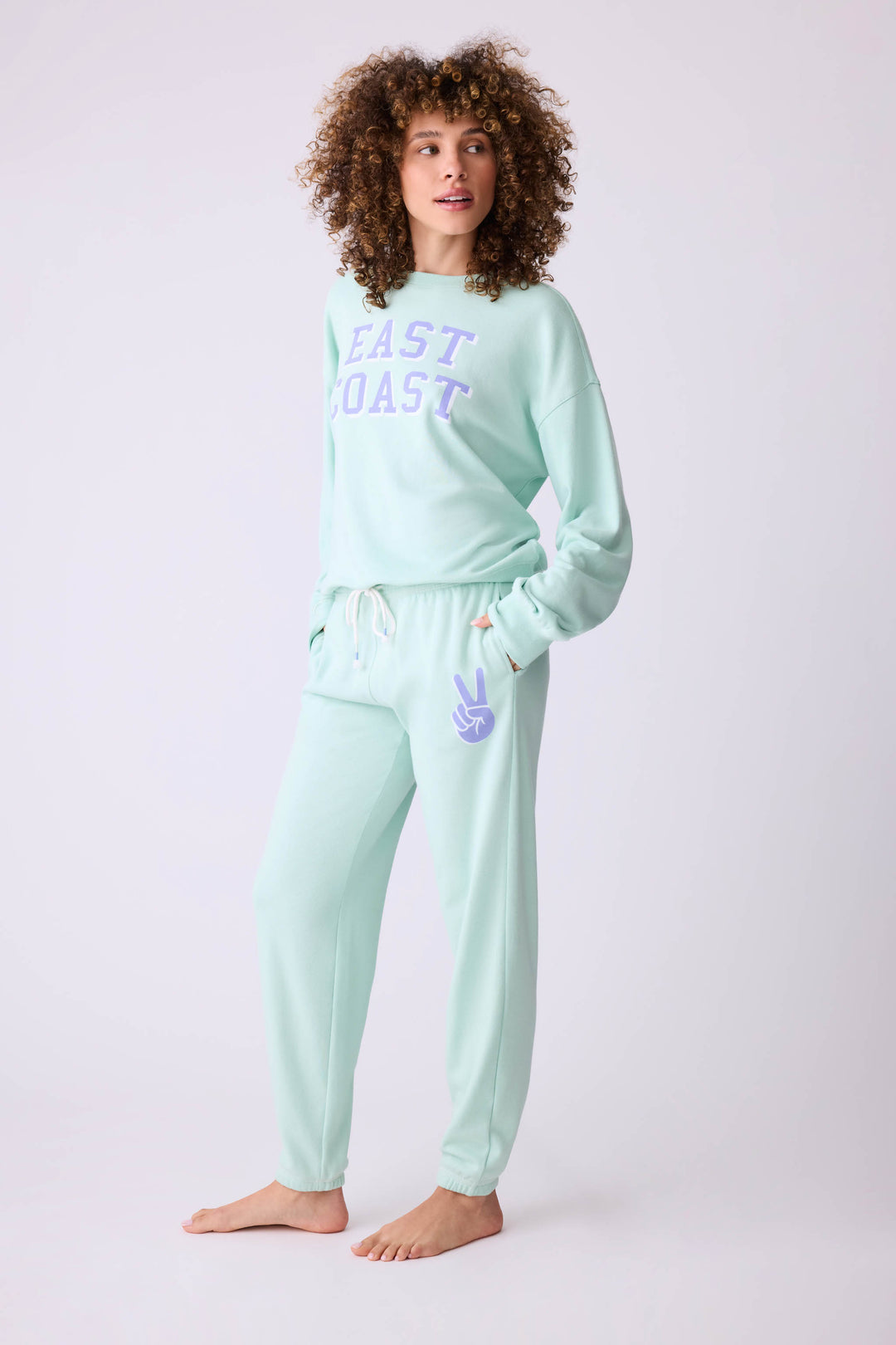 Women's vintage fleece jogger set in light green with EAST COAST graphic print.