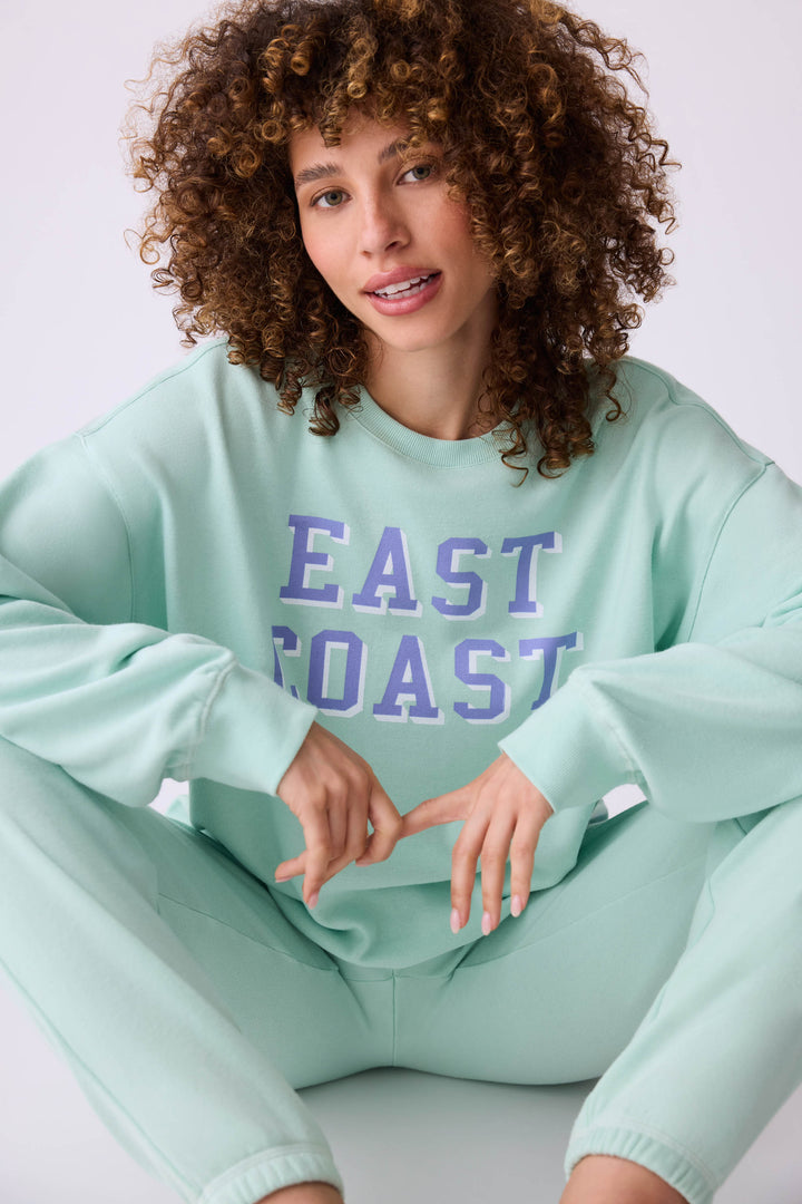 Women's vintage fleece jogger set in light green with EAST COAST graphic print.