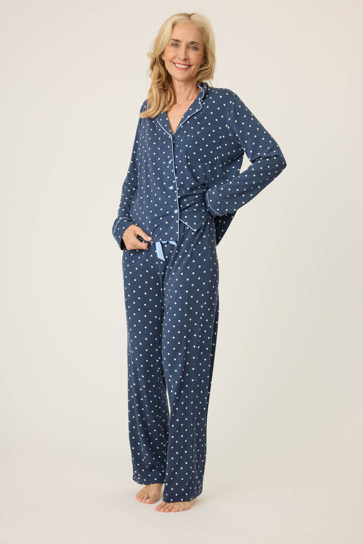 Women's navy blue w/ivory polka dot pajama set in modal jersey. Top is button-front with collar & contrast piping. Pant has tie waist & contrast piping on sideseams.