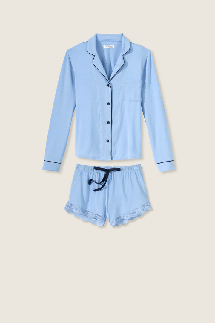 Women's bright blue pajama set in modal jersey. Top is button-front with collar & contrast navy piping. Short has lace trim hem & navy tie waist.