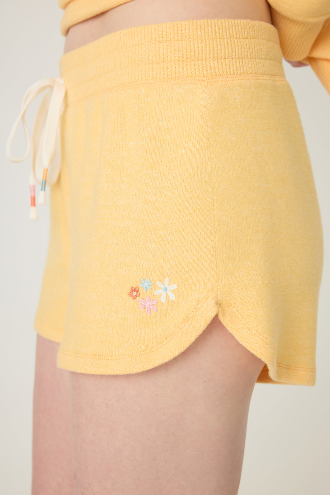 Women's sun yellow lounge short with small floral embroidery on cuff.