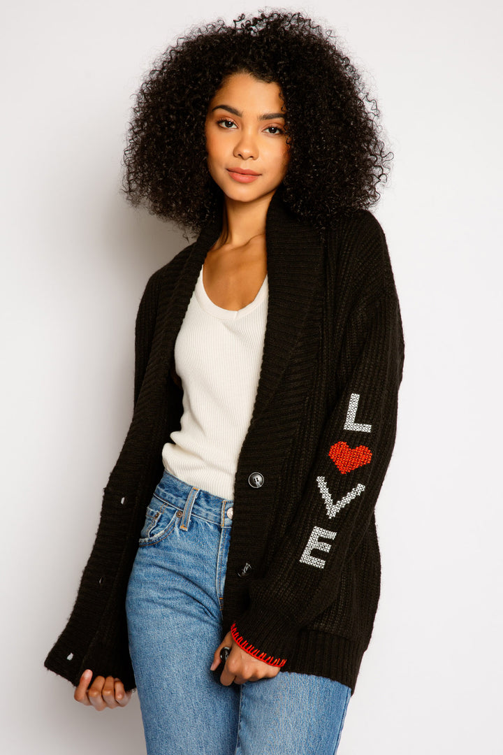 Black cardigan sweater, shawl collar, 3-button close & front pockets. Love & floral sleeve embroideries. (7325665067108)